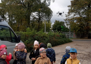 Dzieci obserwują drona.