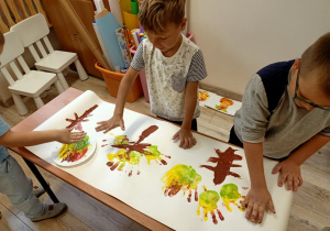 chłopcy malują dłońmi