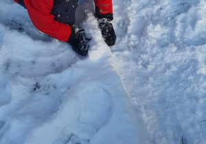 Chłopiec buduje brzeg lodowiska.