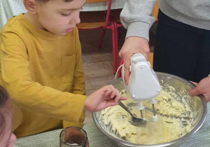 Chłopiec dodaje cukier do masła.