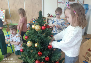 Dzieci ubierają choinkę