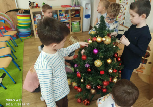 Dzieci ubierają choinkę