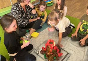 dzieci wykonują doświadczenie wybuch wulkanu