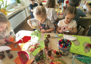 dzieci robią papierowe dinozaury