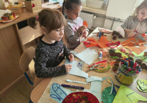 dzieci robią papierowe dinozaury