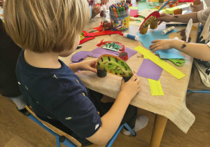 dzieci robią papierowe dinozaury