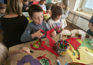 dzieci robią papierowe dinozaury