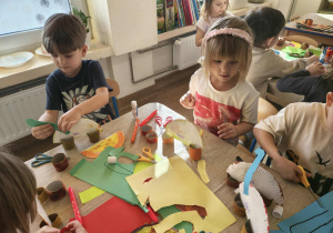 dzieci robią papierowe dinozaury