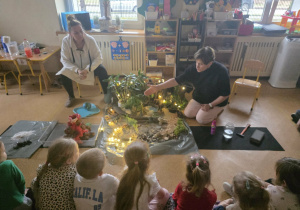 Dzieci słuchają opowieści i oglądają eksperymenty.