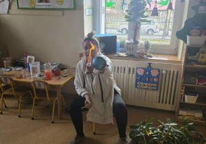 Dzieci słuchają opowieści i oglądają eksperymenty.