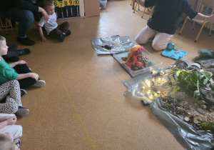 Dzieci słuchają opowieści i oglądają eksperymenty.