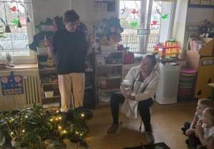 Dzieci słuchają opowieści i oglądają eksperymenty.