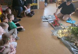 Dzieci słuchają opowieści i oglądają eksperymenty.