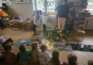 Dzieci słuchają opowieści i oglądają eksperymenty.