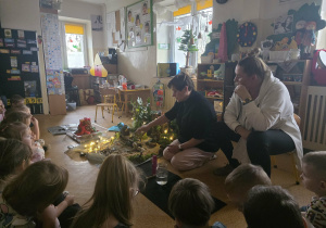 Dzieci słuchają opowieści i oglądają eksperymenty.