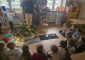 Dzieci słuchają opowieści i oglądają eksperymenty.