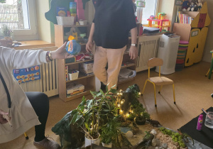 Dzieci słuchają opowieści i oglądają eksperymenty.