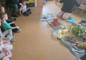 Dzieci słuchają opowieści i oglądają eksperymenty.