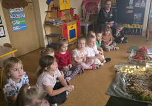 Dzieci słuchają opowieści i oglądają eksperymenty.