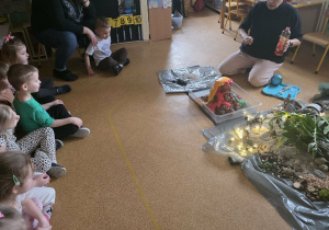 Dzieci słuchają opowieści i oglądają eksperymenty.