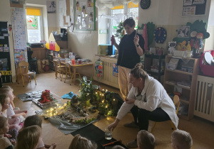 Dzieci słuchają opowieści i oglądają eksperymenty.