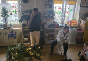 Dzieci słuchają opowieści i oglądają eksperymenty.