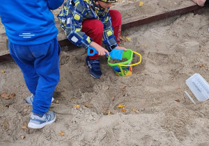Dzieci badają właściwości piasku.